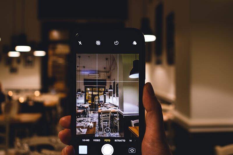 Person holding smartphone managing social media content across platforms